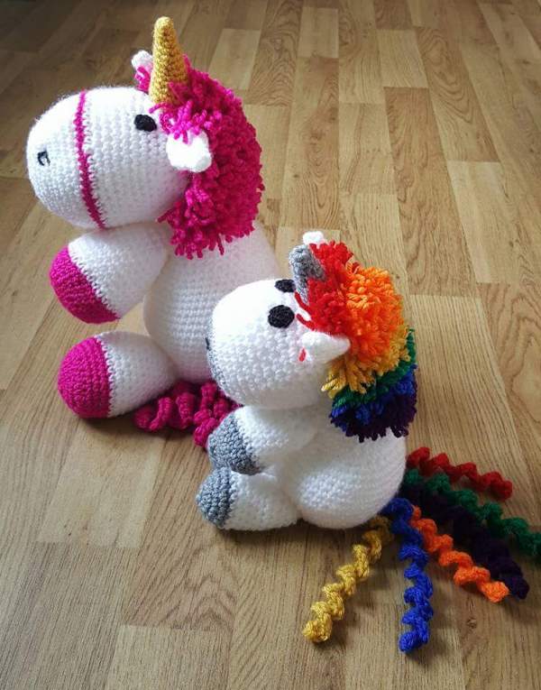 A large and a small crochet unicorn sat together